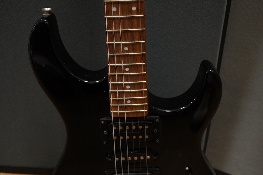 A Yamaha ERG121 electric guitar in black finish, with a soft gig case